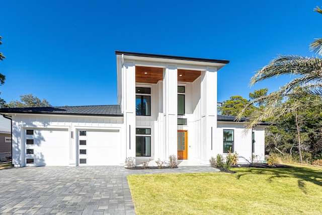 contemporary house featuring a garage and a front yard