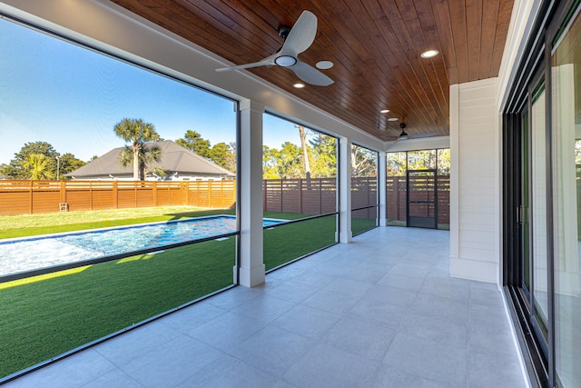 unfurnished sunroom featuring ceiling fan and wood ceiling