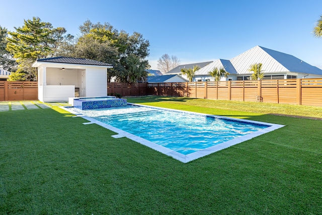 view of swimming pool with an in ground hot tub and a yard