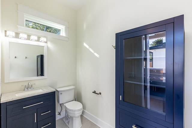 bathroom with vanity, toilet, and tile patterned flooring