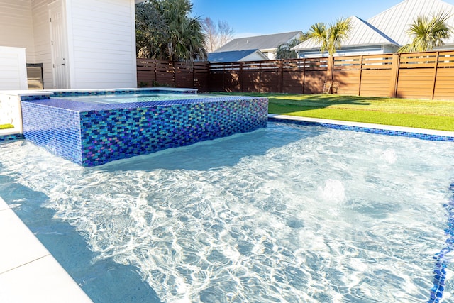 view of pool featuring a yard and a hot tub