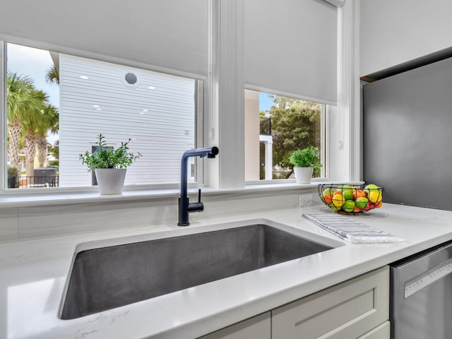 details with white cabinetry, sink, and dishwasher