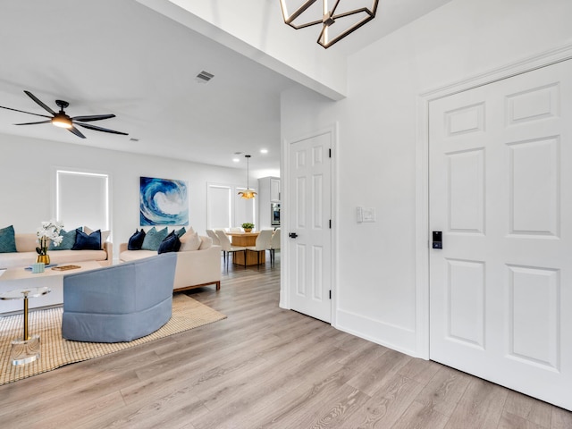 living room with ceiling fan and light hardwood / wood-style flooring