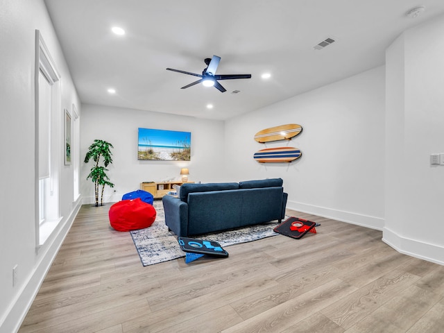 living room with light hardwood / wood-style floors and ceiling fan