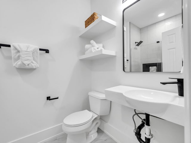 bathroom featuring tiled shower and toilet