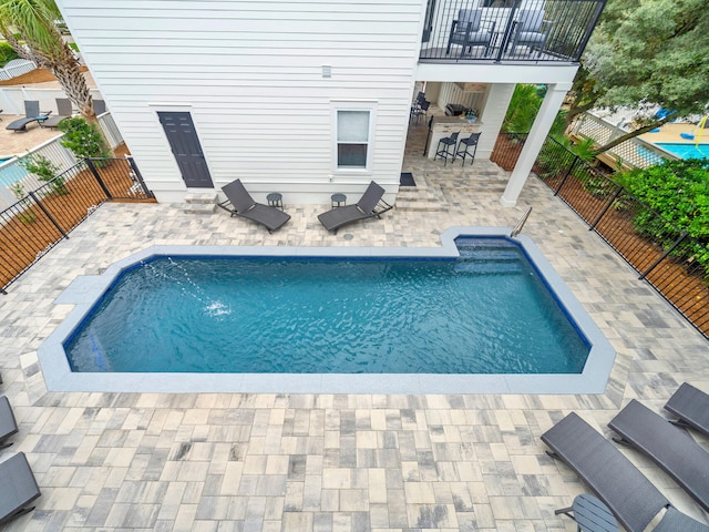 view of swimming pool featuring exterior bar and a patio