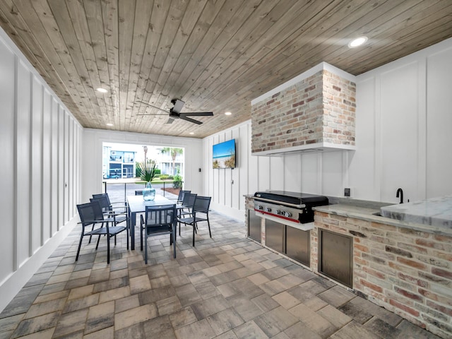 view of patio / terrace featuring ceiling fan, an outdoor kitchen, and a grill