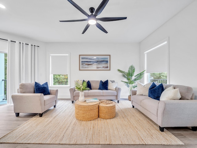 living room with light hardwood / wood-style flooring, a healthy amount of sunlight, and ceiling fan