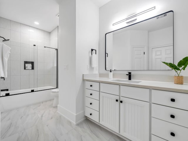 full bathroom featuring enclosed tub / shower combo, vanity, and toilet