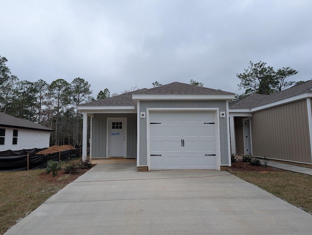 single story home with a garage, roof with shingles, and driveway