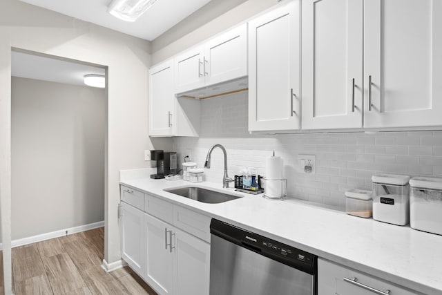 kitchen with dishwasher, backsplash, sink, and white cabinets