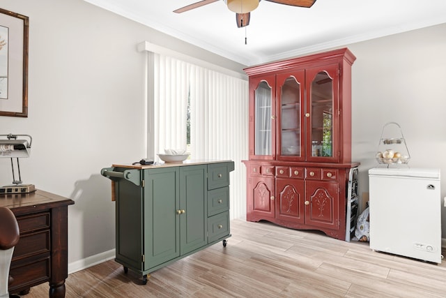 interior space with light wood-type flooring, ceiling fan, and crown molding