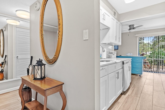 kitchen featuring white cabinetry, sink, blue cabinetry, light hardwood / wood-style flooring, and dishwasher