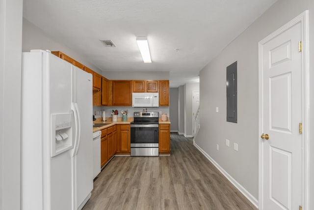 kitchen featuring electric panel, white appliances, and light hardwood / wood-style floors