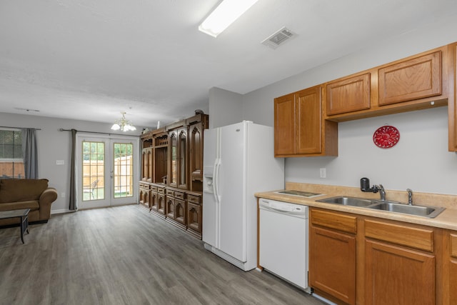 kitchen with french doors, wood-type flooring, a notable chandelier, sink, and white appliances