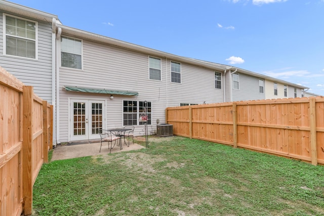 rear view of house with central air condition unit, a patio, and a yard