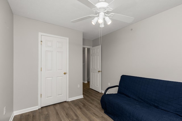 sitting room with dark hardwood / wood-style flooring and ceiling fan