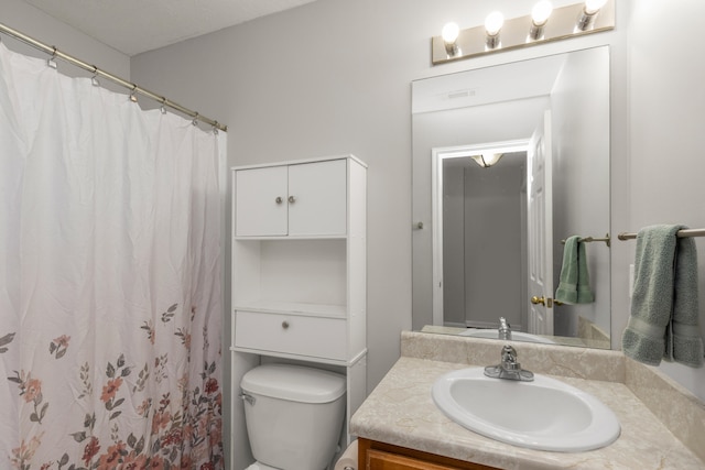 bathroom with curtained shower, vanity, and toilet