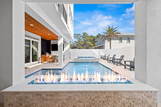 view of pool with area for grilling, a patio, and an in ground hot tub