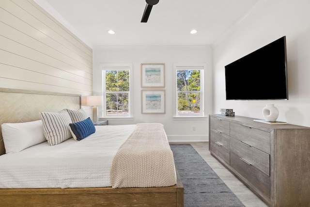 bedroom with ornamental molding, light wood-type flooring, and ceiling fan