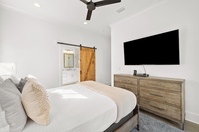 bedroom with hardwood / wood-style flooring, ornamental molding, ceiling fan, a barn door, and connected bathroom