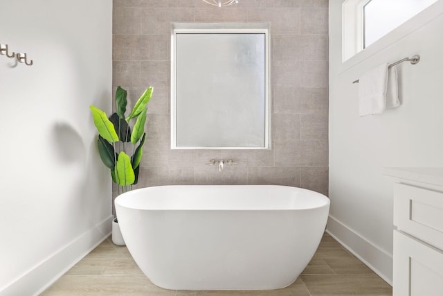 bathroom featuring tile walls, hardwood / wood-style floors, vanity, and a tub