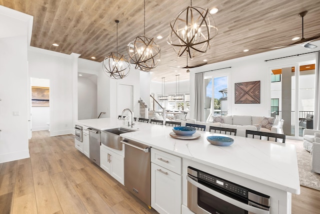 kitchen featuring wood ceiling, sink, a center island with sink, and light hardwood / wood-style flooring