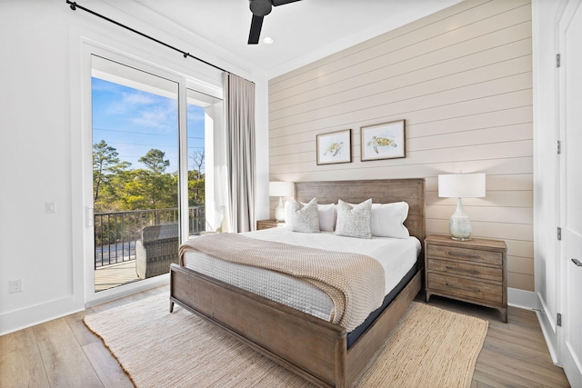 bedroom with wood walls, hardwood / wood-style flooring, ceiling fan, access to exterior, and crown molding