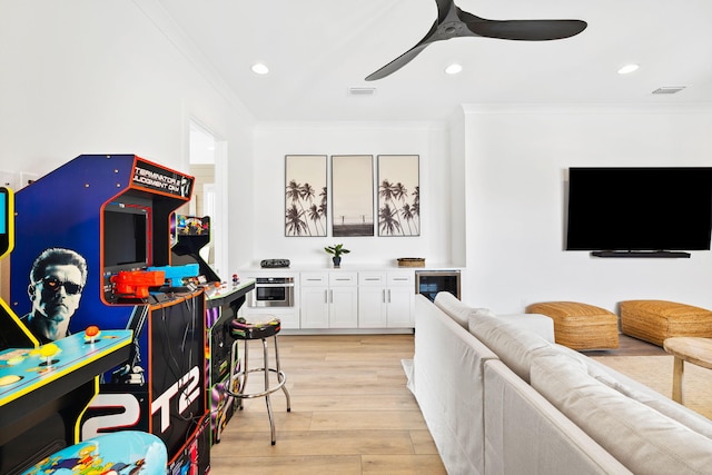 living room with light hardwood / wood-style flooring, ceiling fan, and crown molding