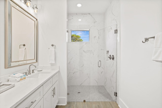 bathroom with vanity, hardwood / wood-style flooring, and a shower with door