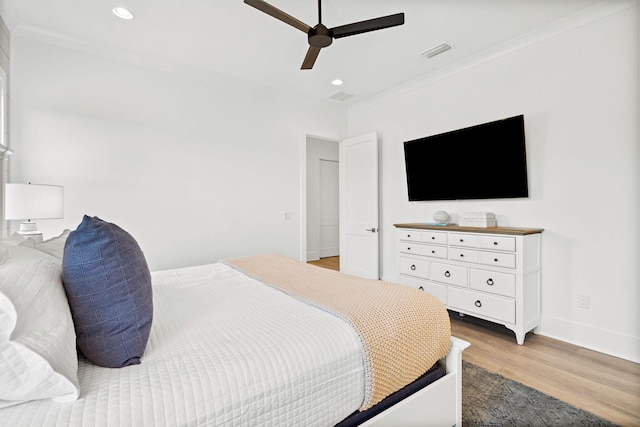 bedroom featuring ceiling fan, light hardwood / wood-style flooring, and ornamental molding