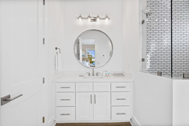 bathroom with tiled shower and vanity