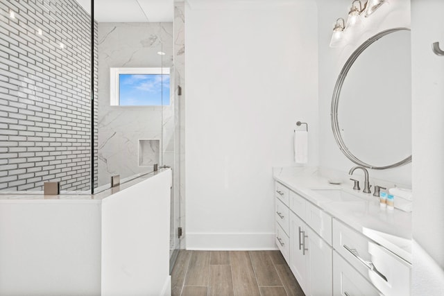 bathroom with hardwood / wood-style floors, a shower with shower door, and vanity