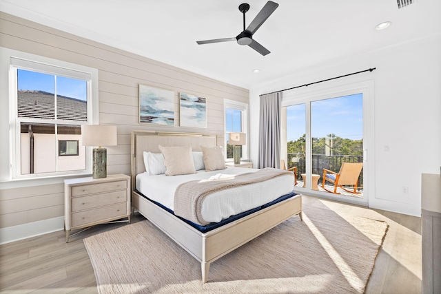 bedroom featuring access to outside, multiple windows, ceiling fan, and light hardwood / wood-style floors