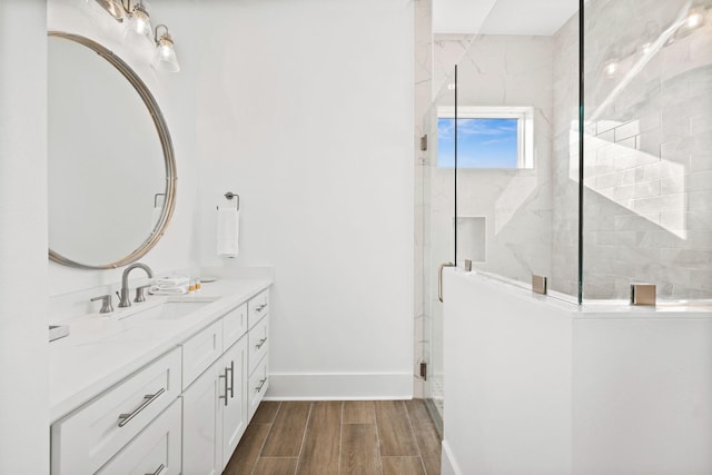 bathroom with hardwood / wood-style floors, a shower with door, and vanity