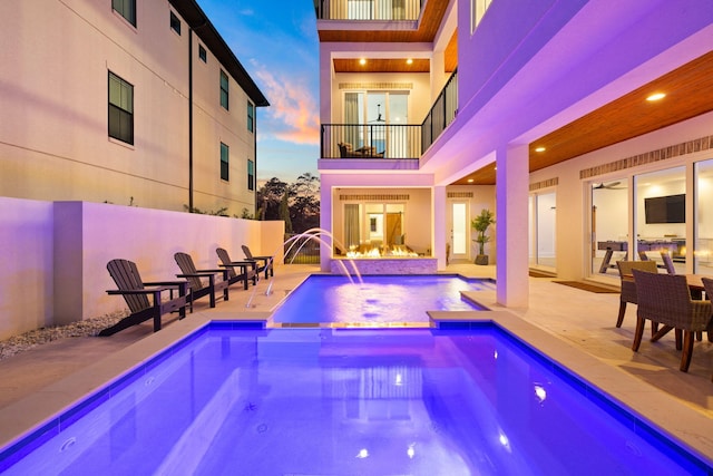 view of pool featuring a patio area, pool water feature, and an in ground hot tub