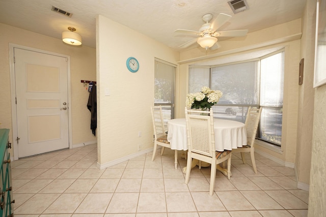 dining space with ceiling fan, a textured ceiling, and light tile patterned floors