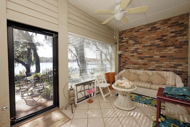 sunroom with a water view and ceiling fan