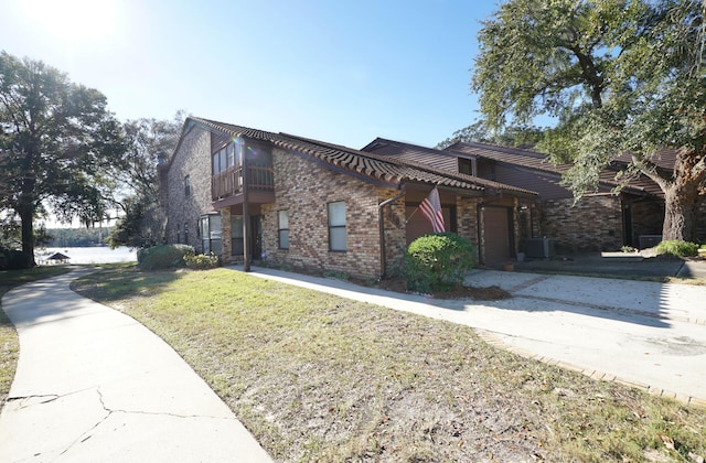 view of front of home with a balcony, a front lawn, and central air condition unit