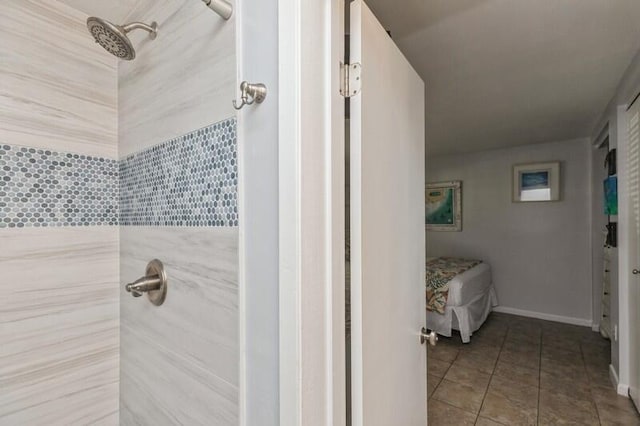 bathroom featuring tiled shower and tile patterned flooring