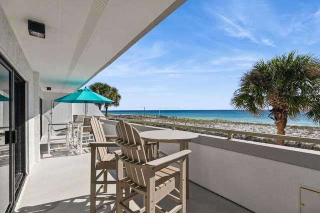 balcony featuring a beach view and a water view