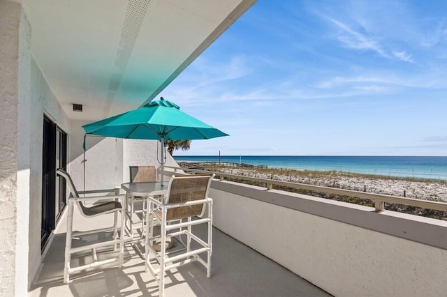 balcony featuring a water view and a beach view