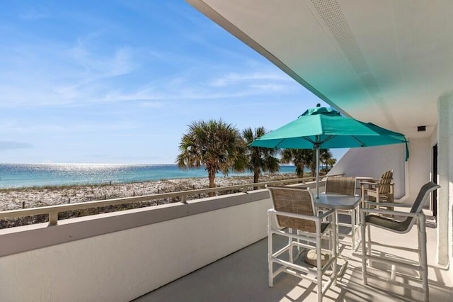 balcony featuring a beach view and a water view