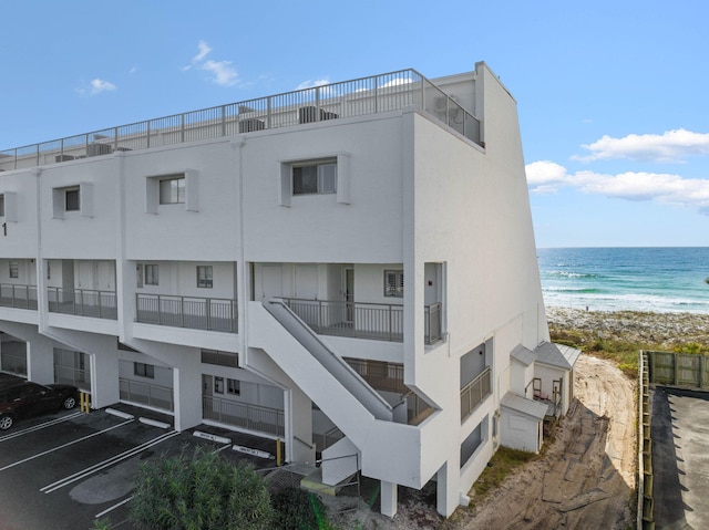 view of building exterior featuring a view of the beach and a water view