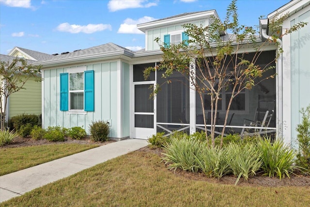 view of exterior entry with a yard