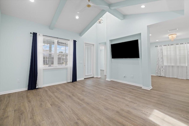 unfurnished living room featuring high vaulted ceiling, light wood-type flooring, ceiling fan, and beam ceiling