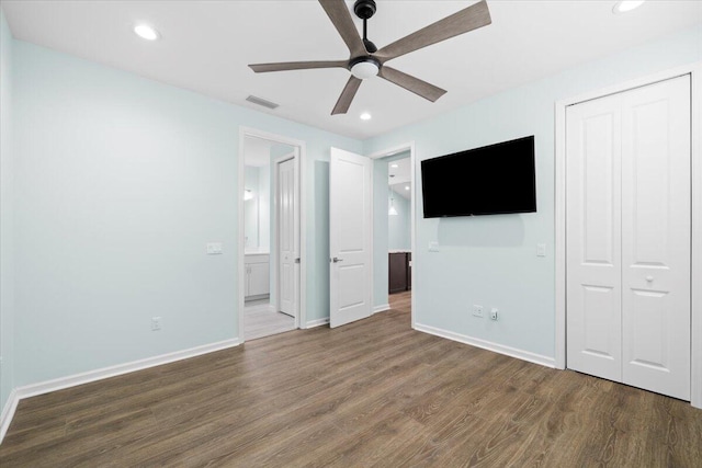 unfurnished bedroom featuring dark hardwood / wood-style floors, ceiling fan, and a closet