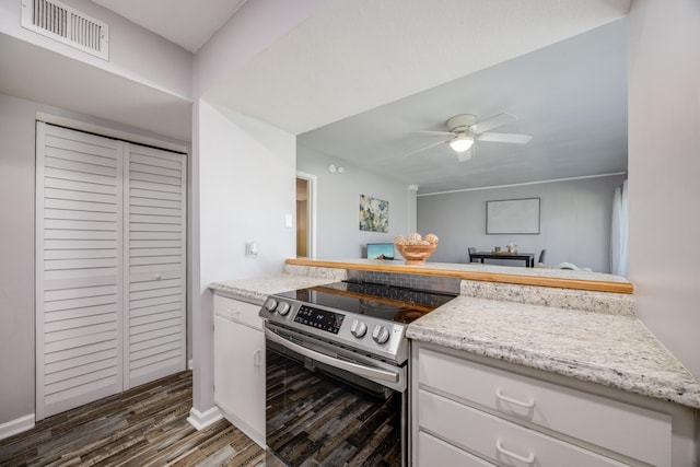 kitchen featuring dark hardwood / wood-style floors, white cabinetry, stainless steel range with electric stovetop, and ceiling fan