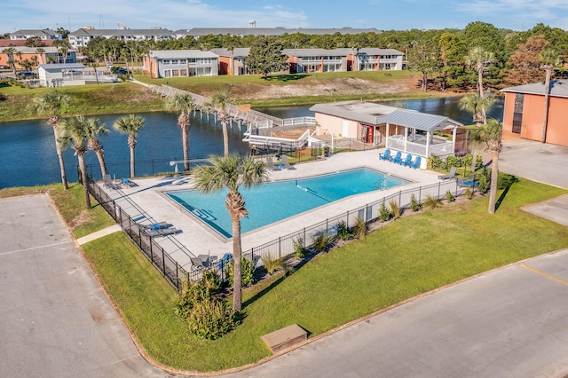 view of swimming pool featuring a lawn and a water view