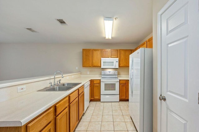 kitchen with kitchen peninsula, light tile patterned floors, white appliances, and sink